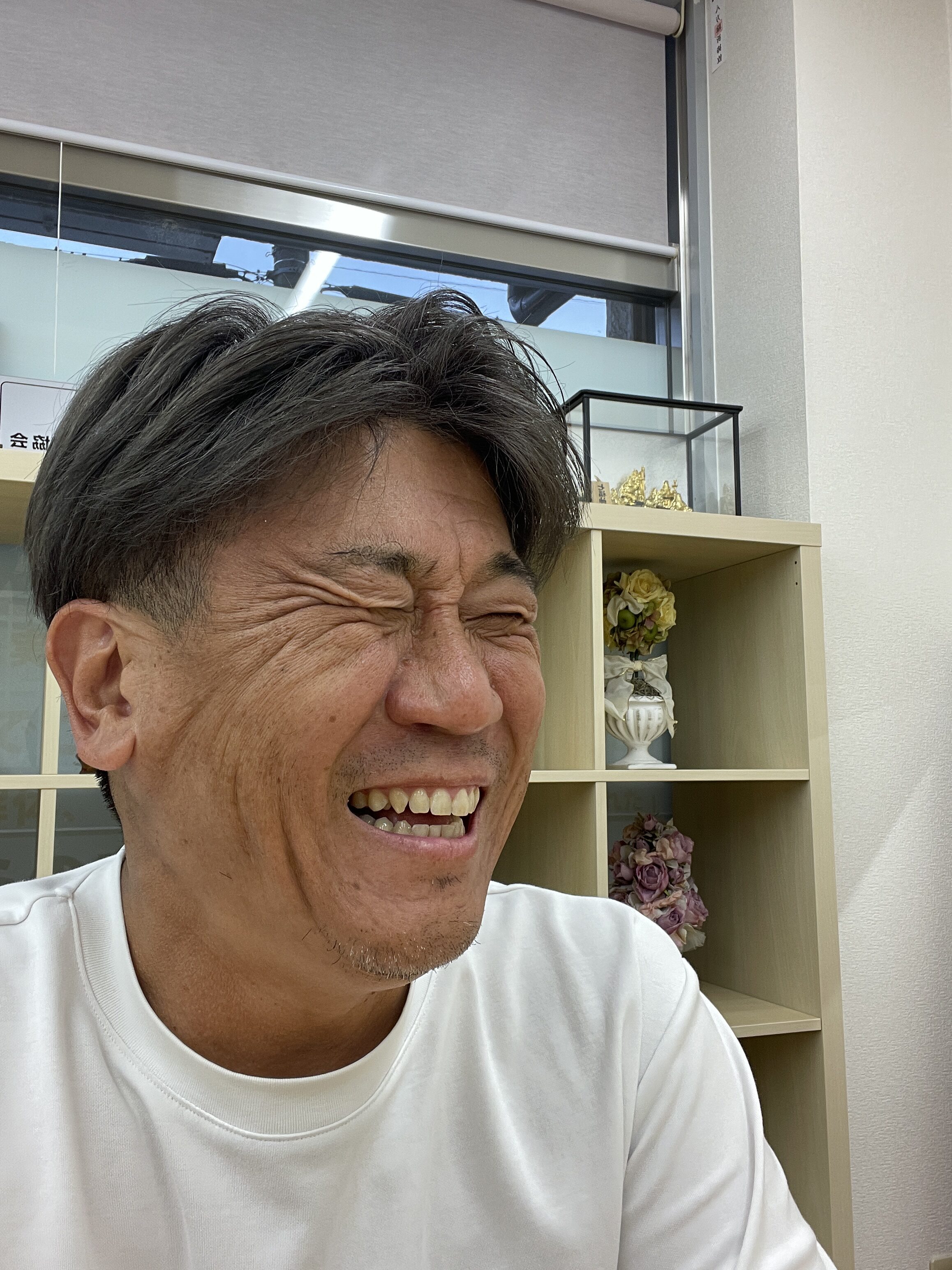 事務所で笑う山本直嗣