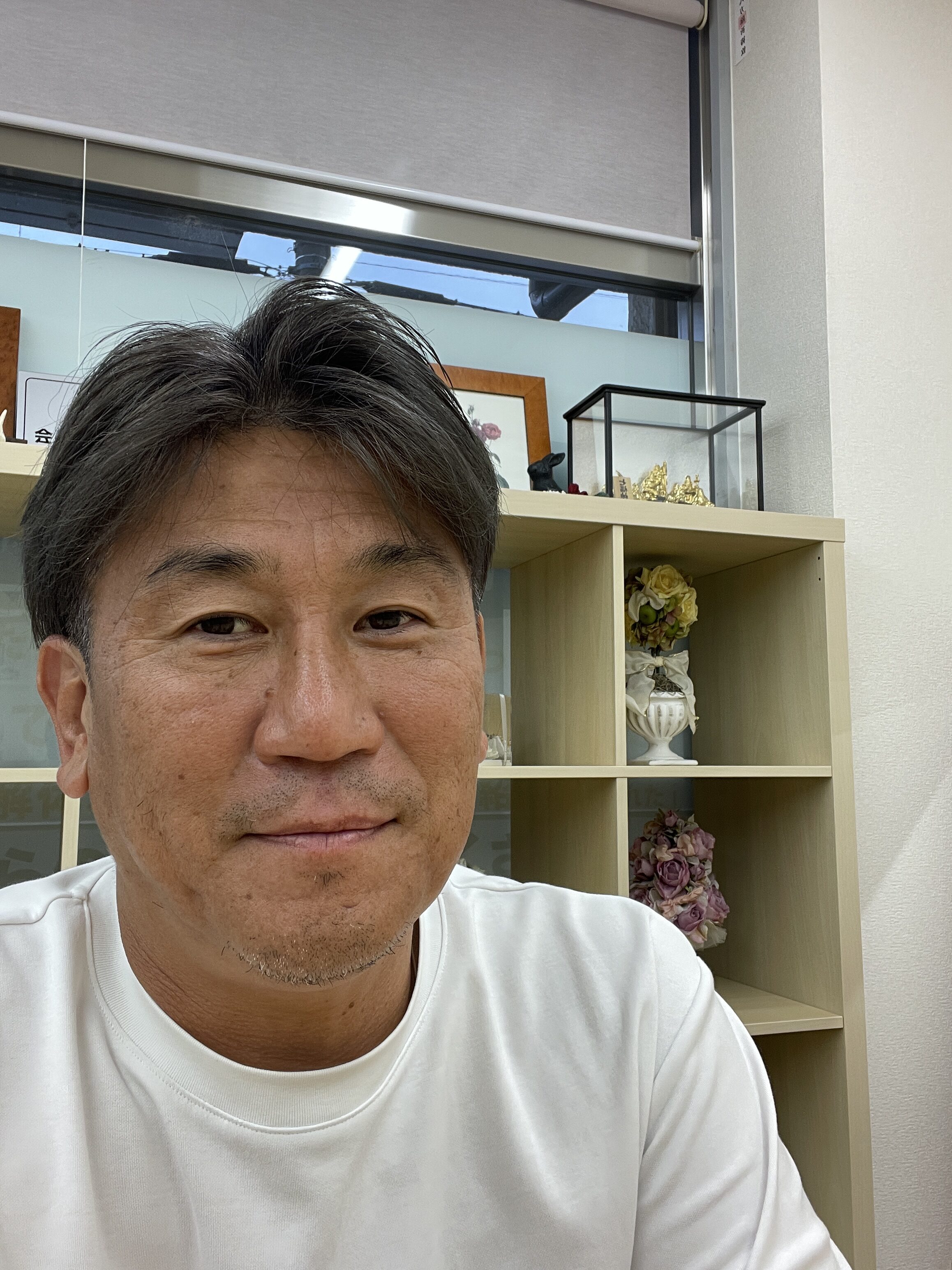 事務所で穏やかな表情を見せる山本直嗣